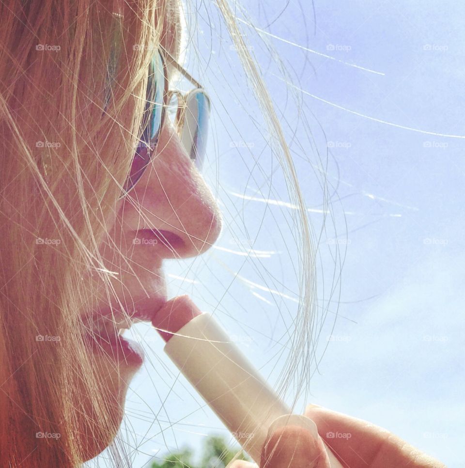 Woman applying lipstick on a sunny day 😎