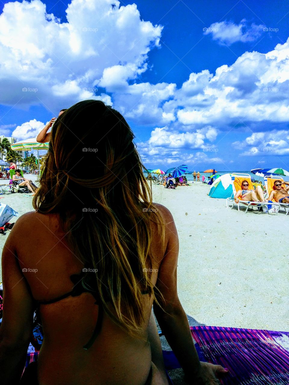 Rear view of a woman sitting at beach