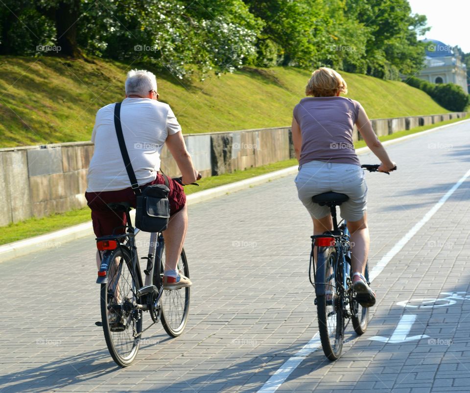 couple riding on a bikes on a street summer time