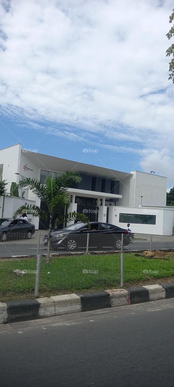 Breathtaking scenery. White building contrasting with the green plants and view of the blue sky and white cloud
