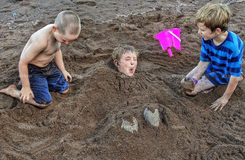 Brothers Piling Sand on Beach
