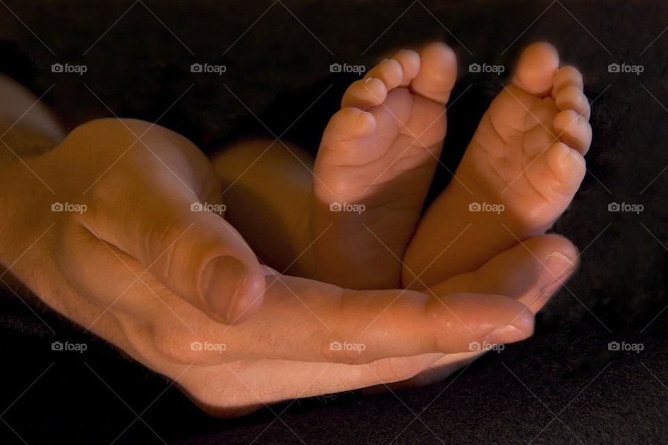 Baby’s feet in father’s hand