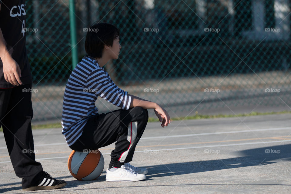 Girl sitting on the basketball 