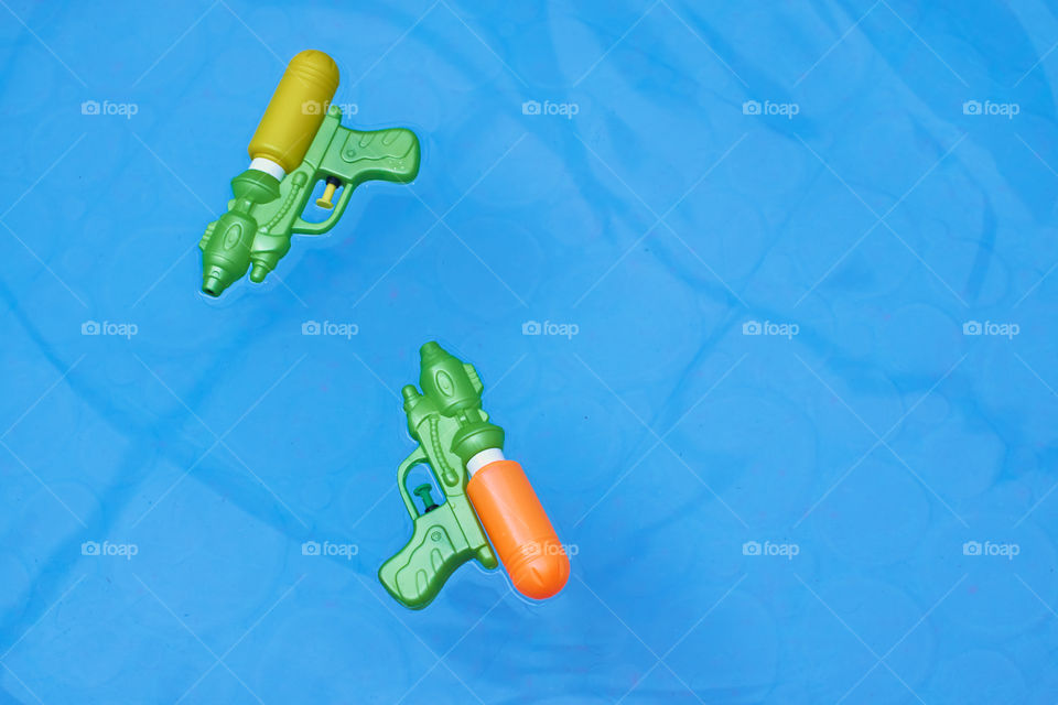 top view of two water guns over the pool for kids play in summer