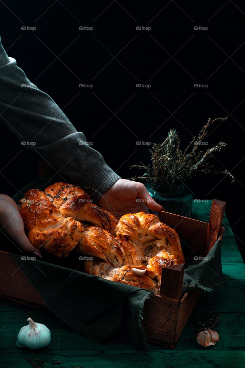 Rosemary twisted loaf bread on a green wooden background, still life, rustic style.