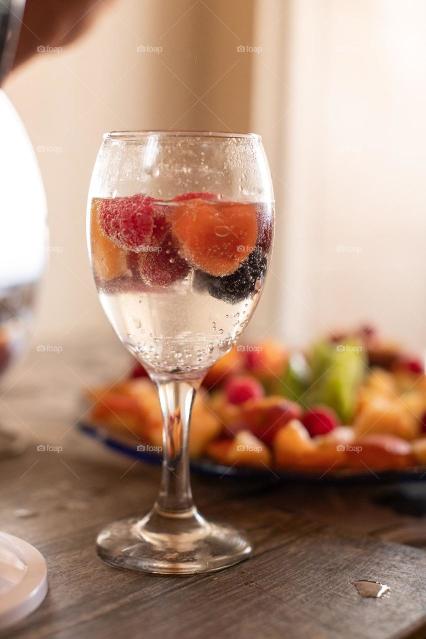 A glass of aqua mineral and fruits