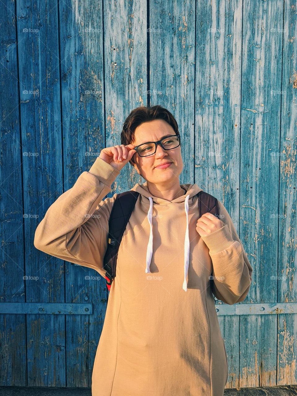 Portrait of young happy, beautiful woman in eye glasses and with short haircut in spring.