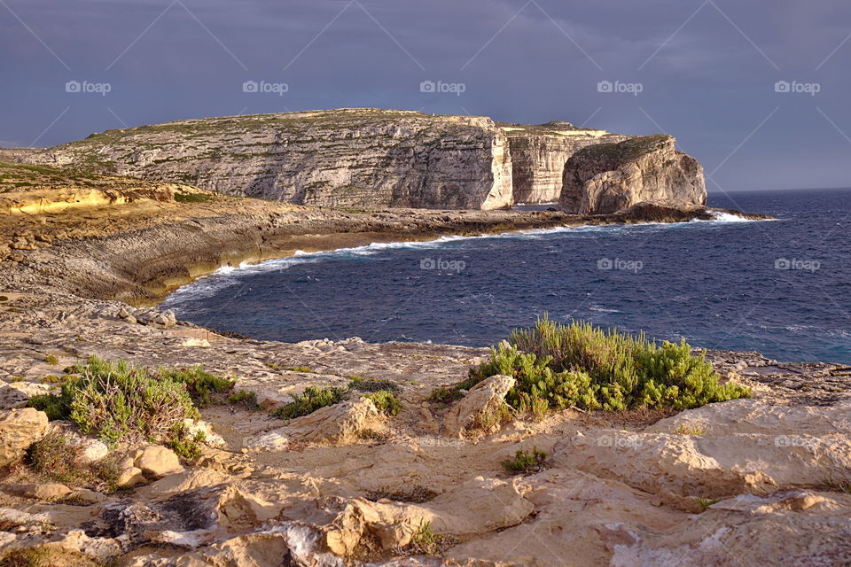 Beautiful dweira bay at sunset with green plants in gozo malta