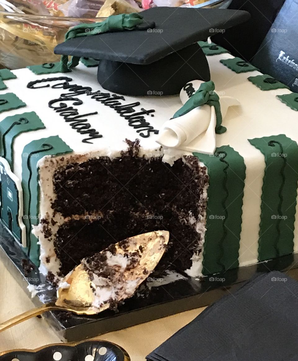 The first piece cut from a beautiful graduation cake