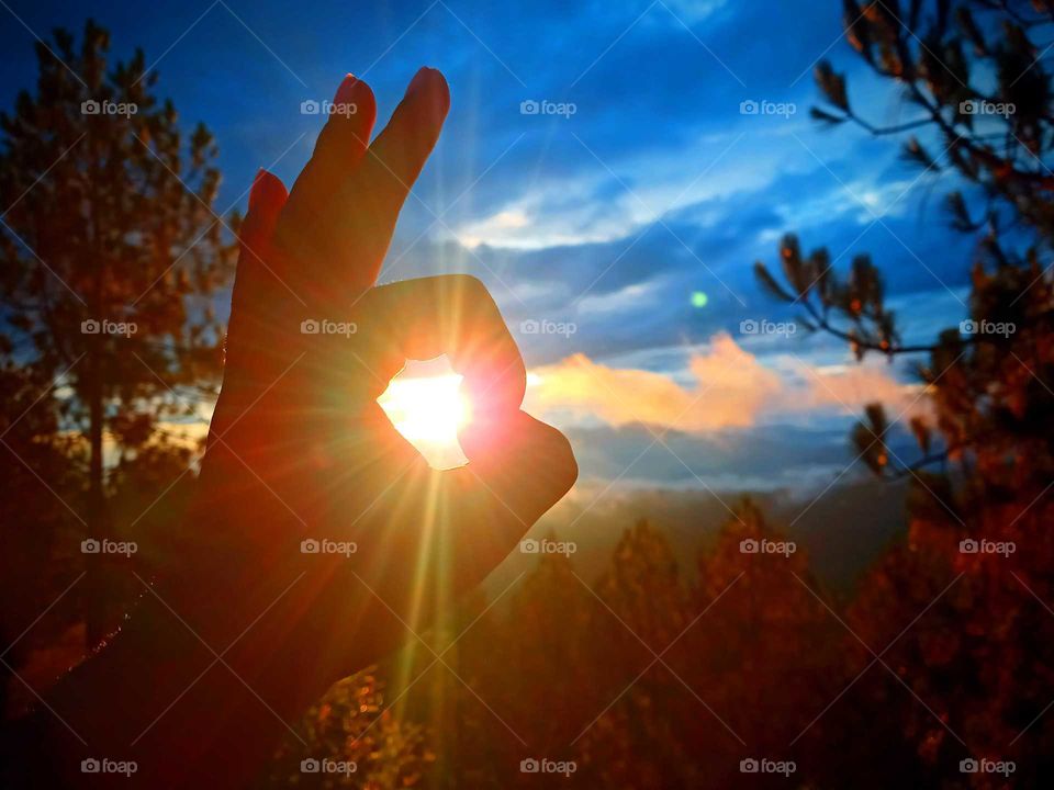 illusion, spreading attractive sunbeam around my hand, natural light, enjoying nature, beautiful yellow coloured rays, captured at the time of sunset