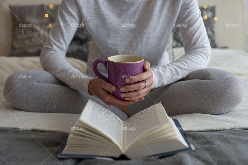 woman relaxing with a mug of tea and a good book