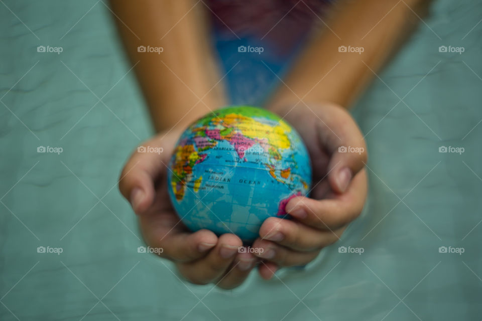 overhead looking down on hands holding world sphere Asia continent