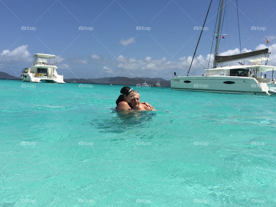 Couple hugging each other in sea near ship