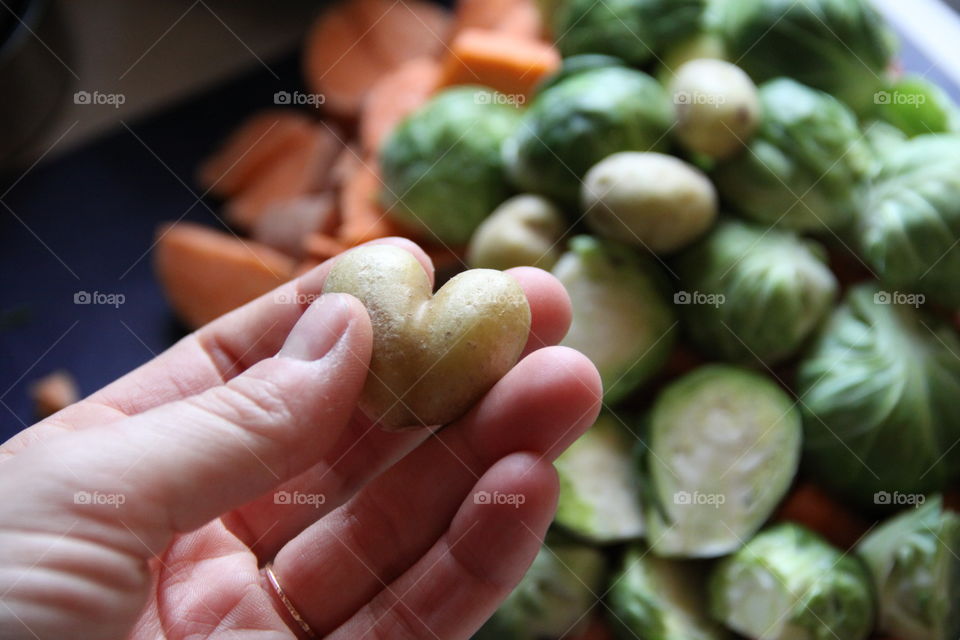 Woman hand holding heart shape potato
