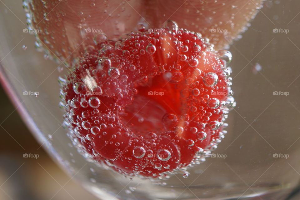 Raspberry submerged in fizzy water