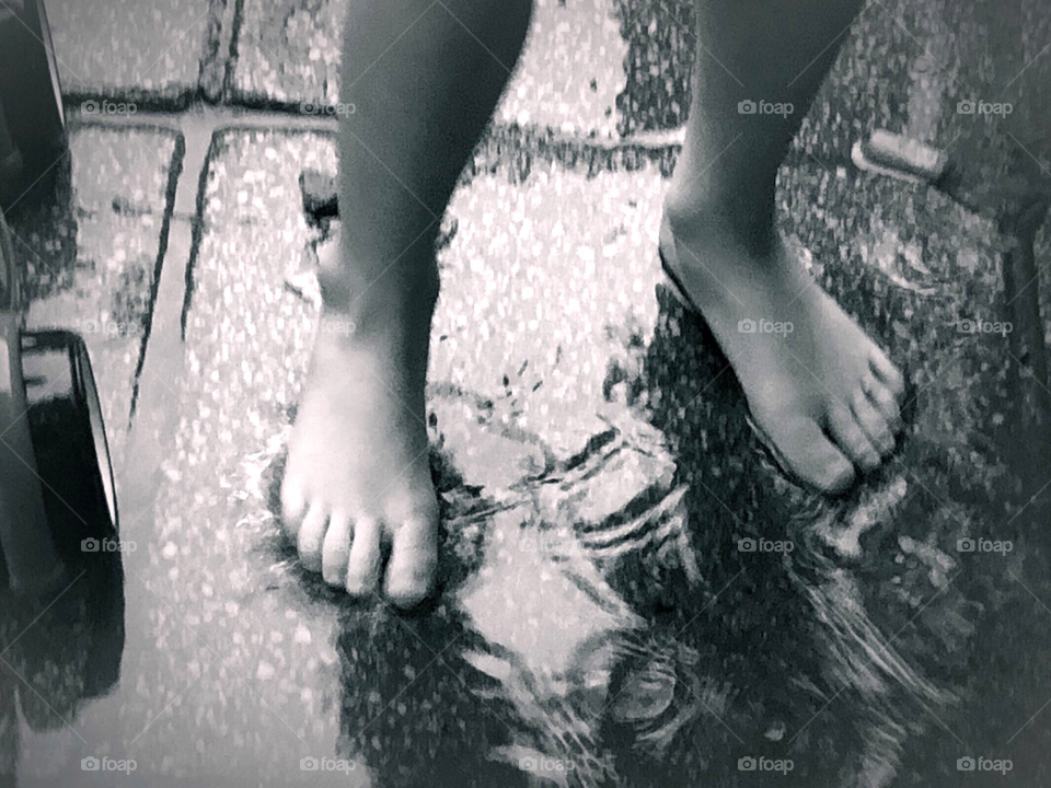 Child’s feet in puddle