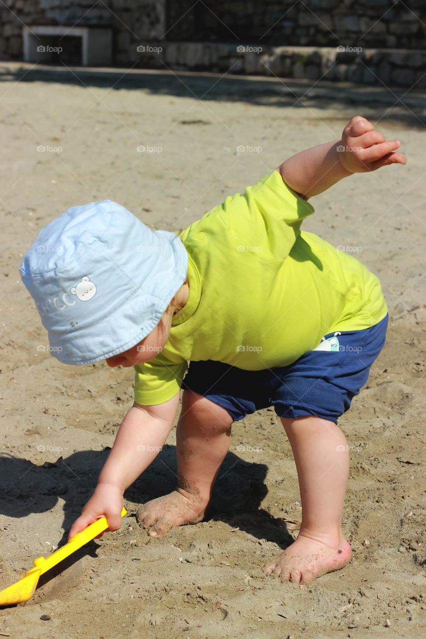 A toddler plays on a beach