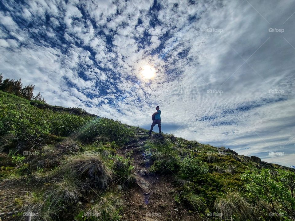 Standing under the sun speckled clouds