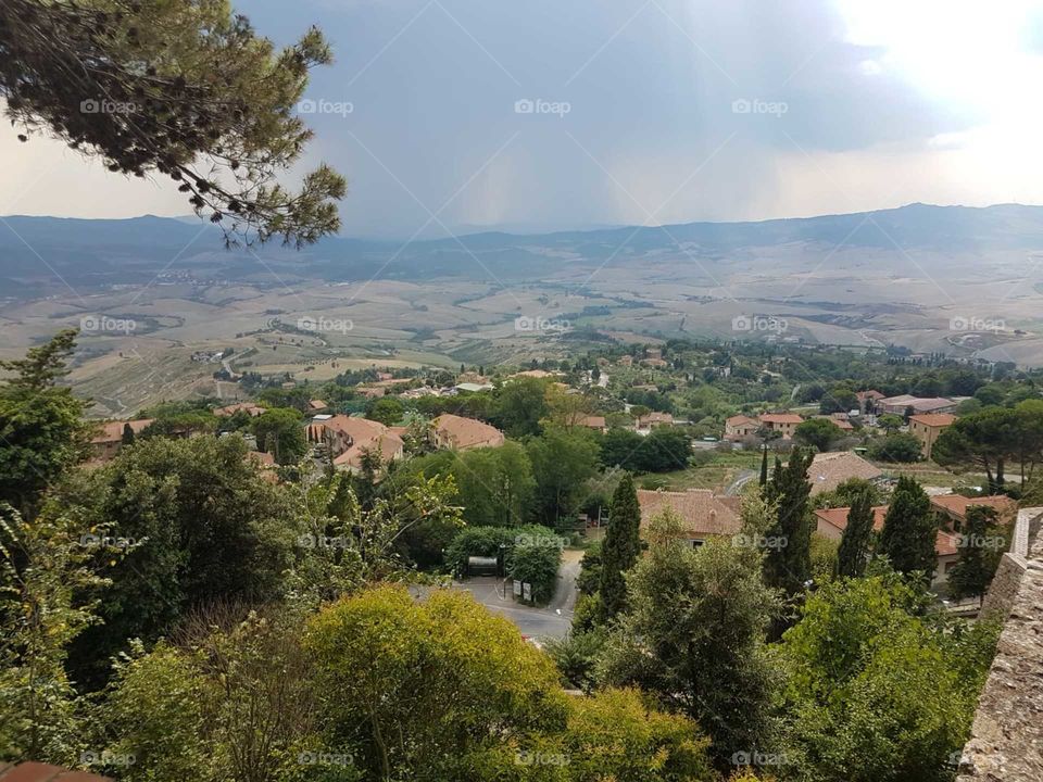 View ov vast natural land in Val d'Orcia (Tuscany) from Volterra  with rain cloud on the background