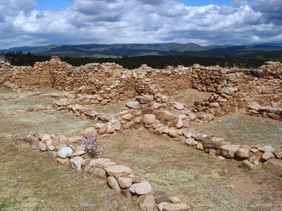 Ruins of Pecos pueblo with rolling hills beyond 