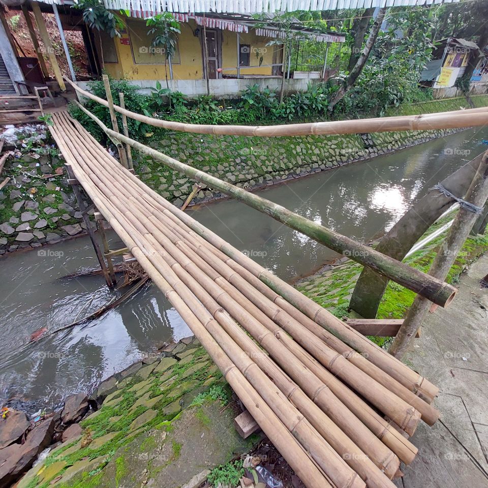 bamboo bridge over the river with clear water