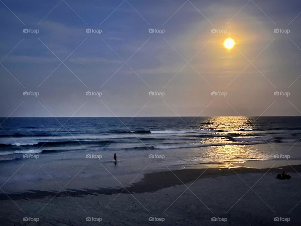 Moonlight shining on the ocean water at the beach