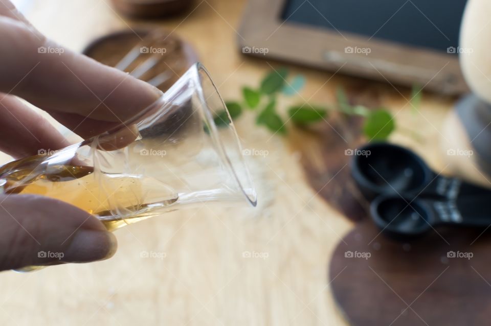 Beauty routine making weekend honey sugar facial exfoliant woman's hand pouring honey with fresh mint and measuring spoons on wooden table in background 