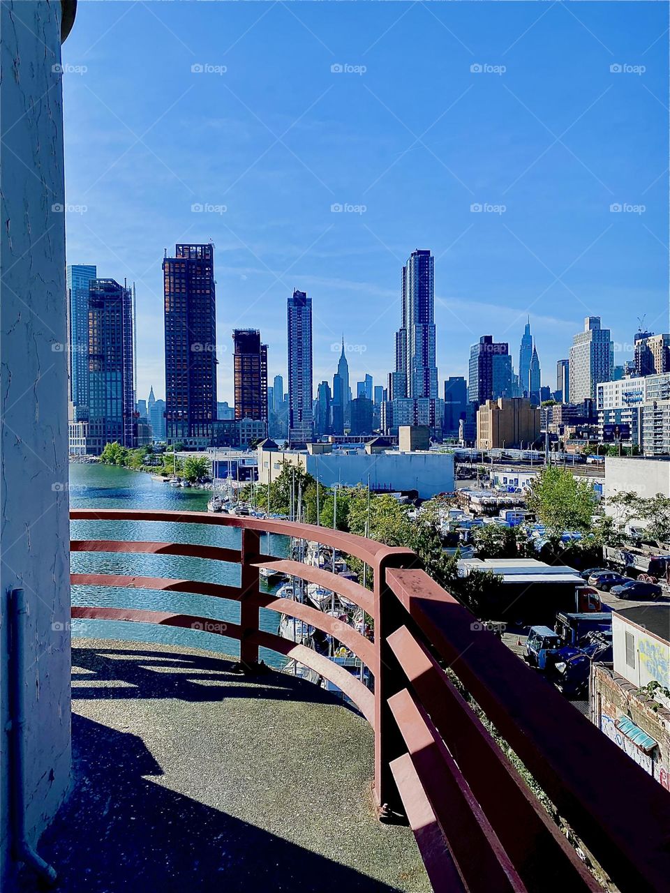From the „Pulaski Bridge“ at „Newtown Creek“ in LIC, Queens views stretch out almost endlessly. Behind the nearby LIC buildings we can see the „Manhattan“ skyline on this gorgeous sunny Indian summer day in early October 2023. Hypnotic Productions