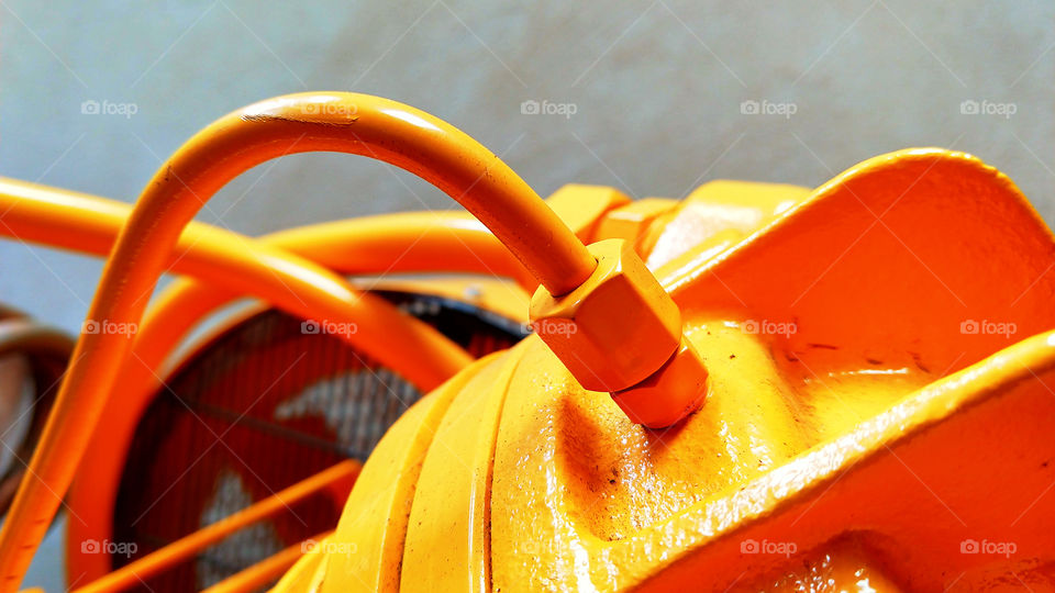 Cor amarela. Parafusos, ferro, motor, parte de um compressor de ar.