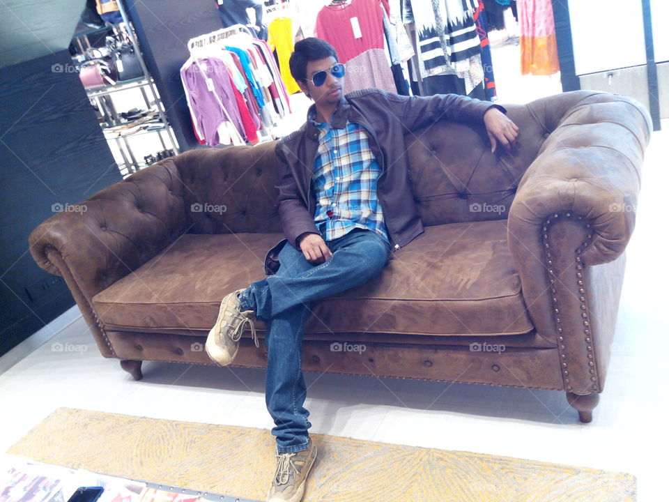 Asian man sitting on sofa in shop