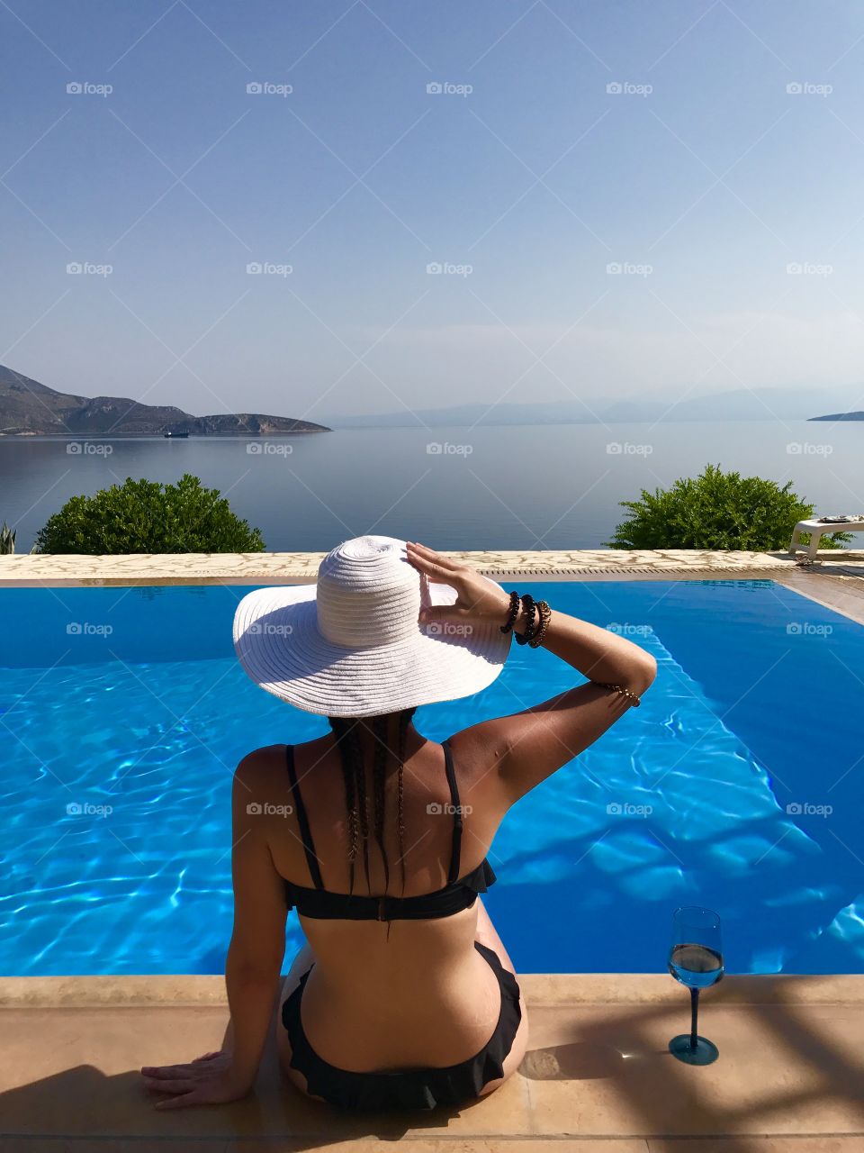Woman with hat in a pool 