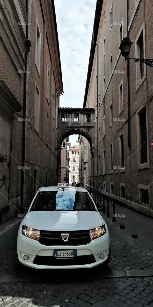 A taxi on a narrow Italian street.