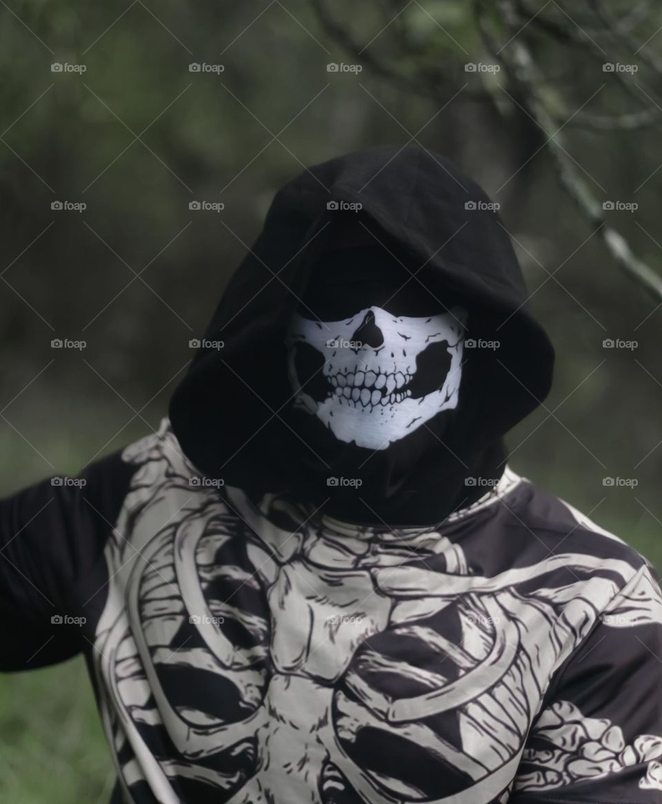 Creepy dude is skeleton themed clothing with hood concealing his eyes