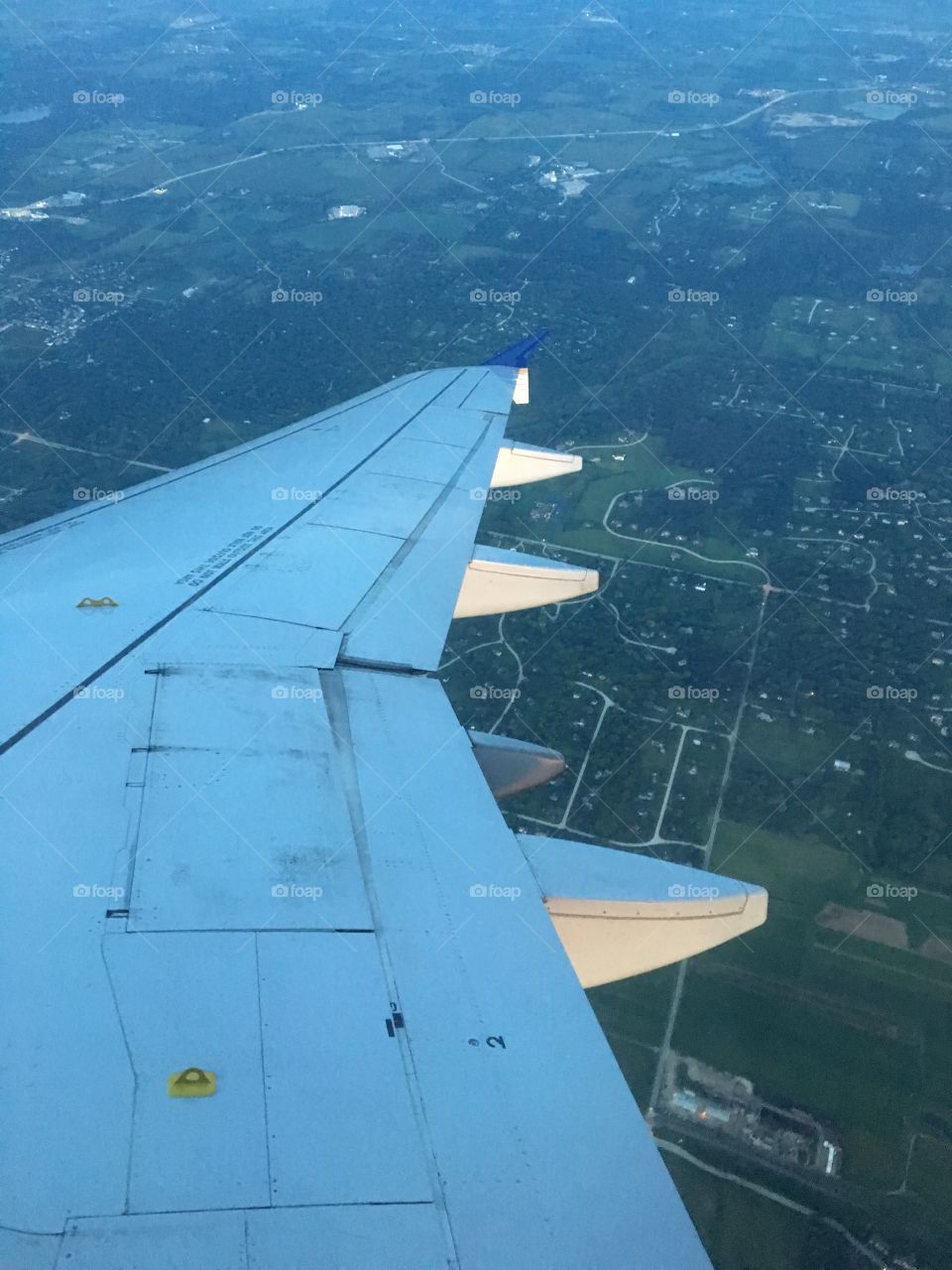 Airplane wing over farms