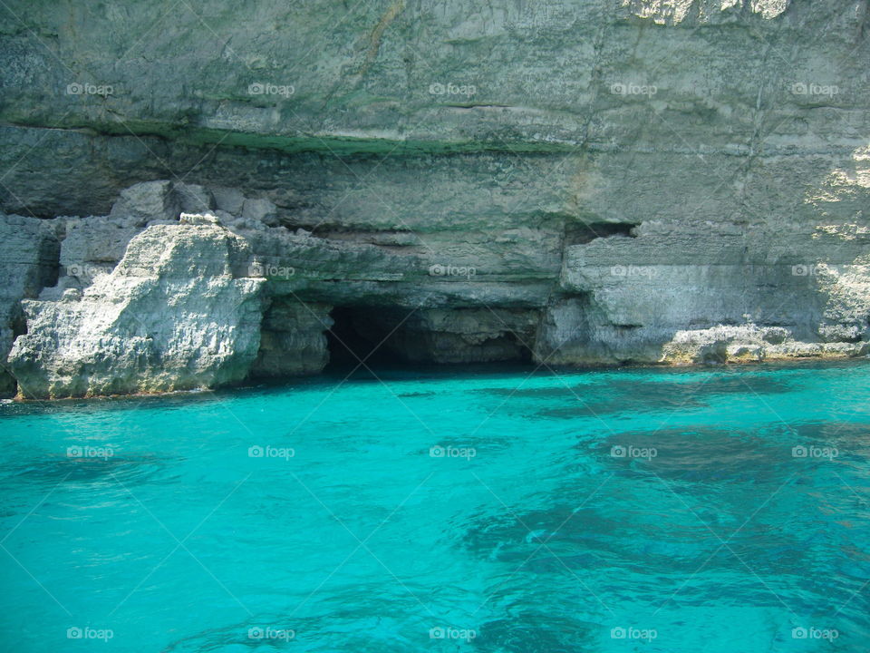 Malta seashore shallow sea and caves in limestone rock