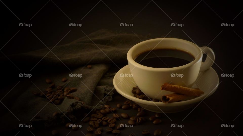 Black coffee with cinnamon and coffee beans