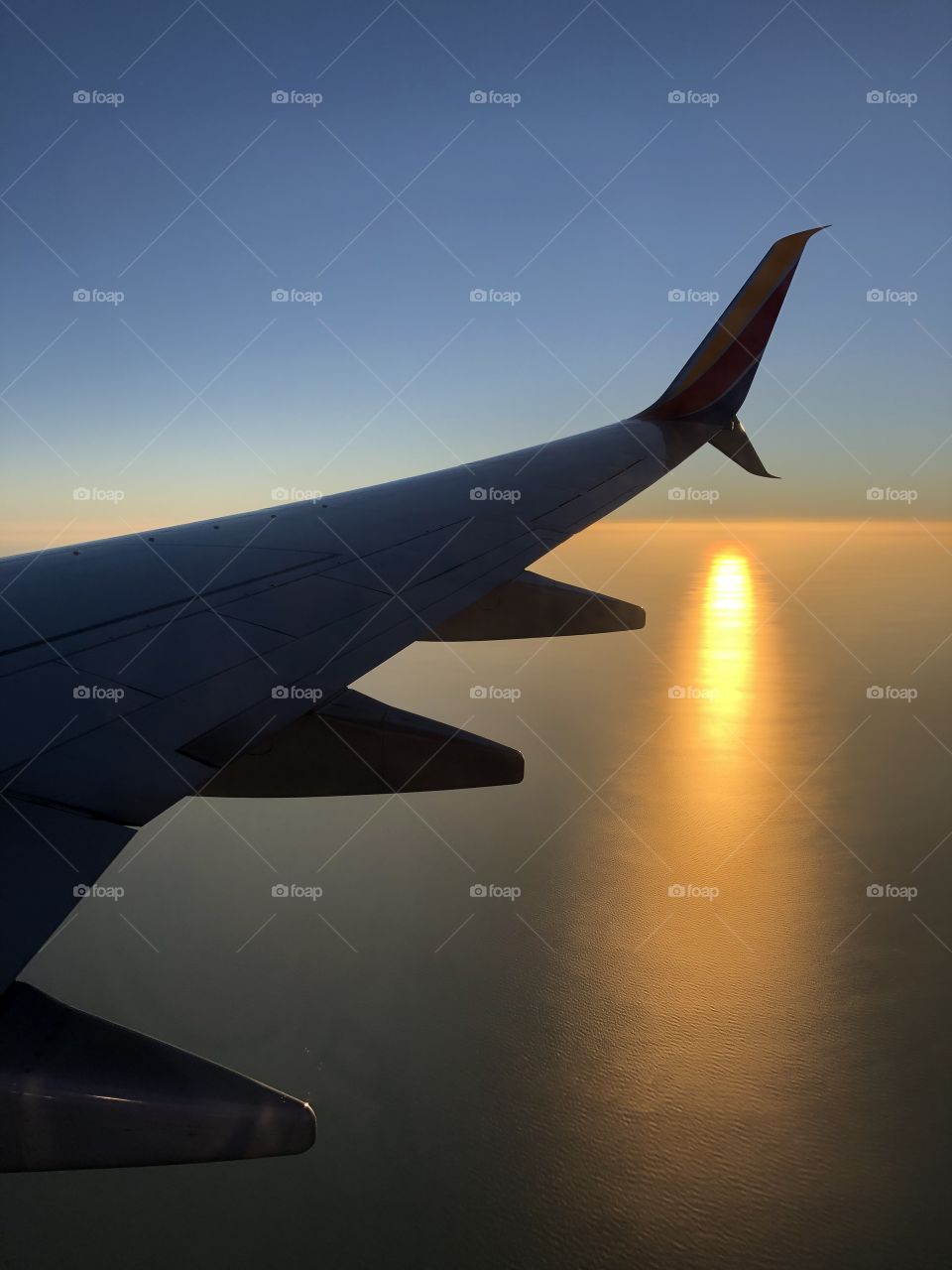 Sunless Sunset on a plane over Gulf of Mexico with view of airplane right wing