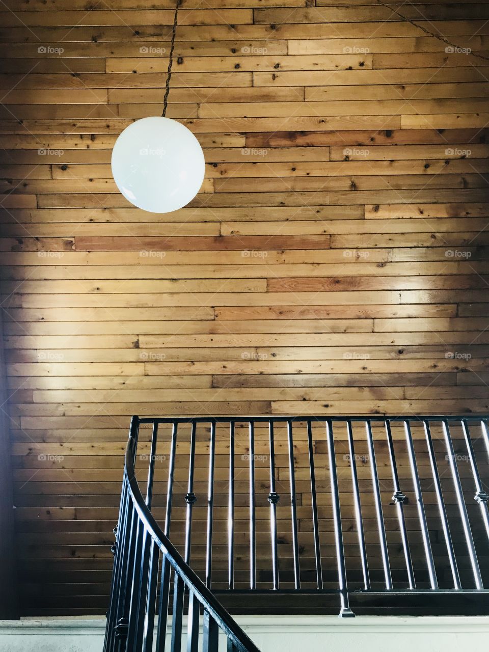 The stairs handle the wood ceiling and the hanging light ball makes it look perfect. 