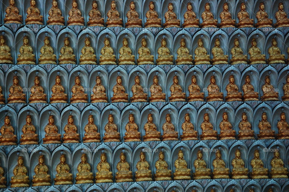 Budha statues covering temple wall