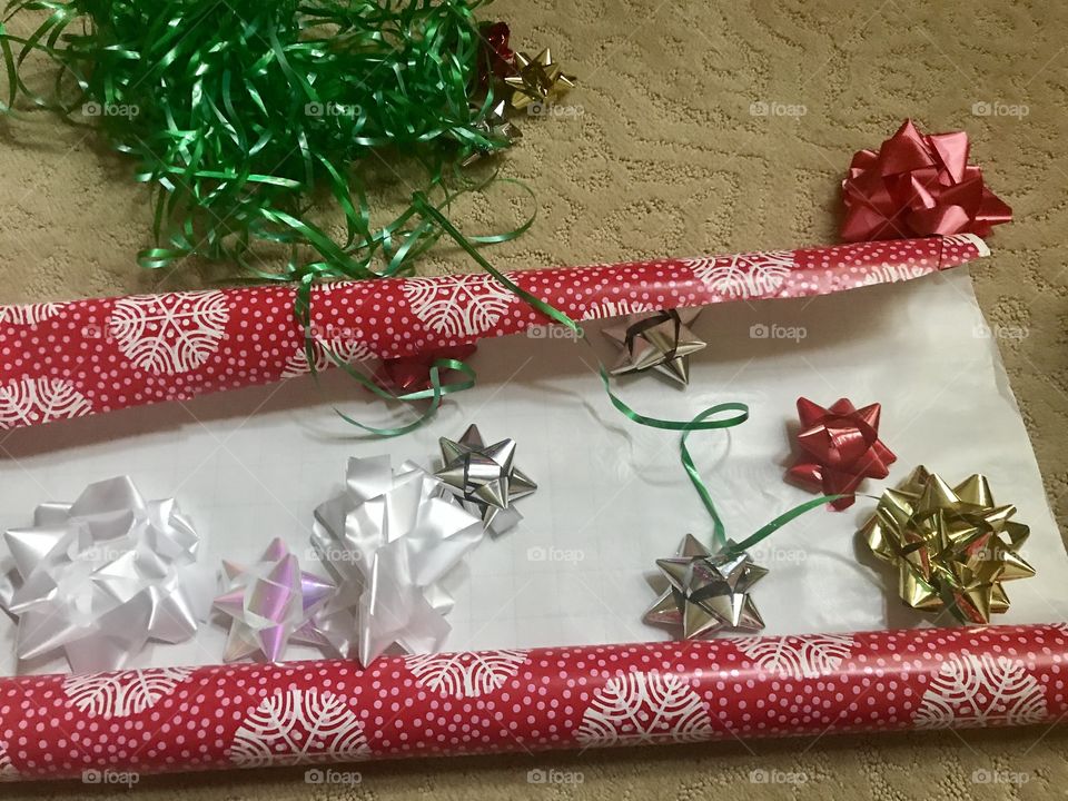 Colorful Wrapping paper, ribbon and bows getting ready to wrap gifts for Christmas this holiday season 