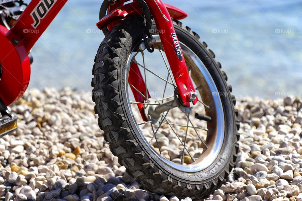 Wheel of a bicycle parked on a beach