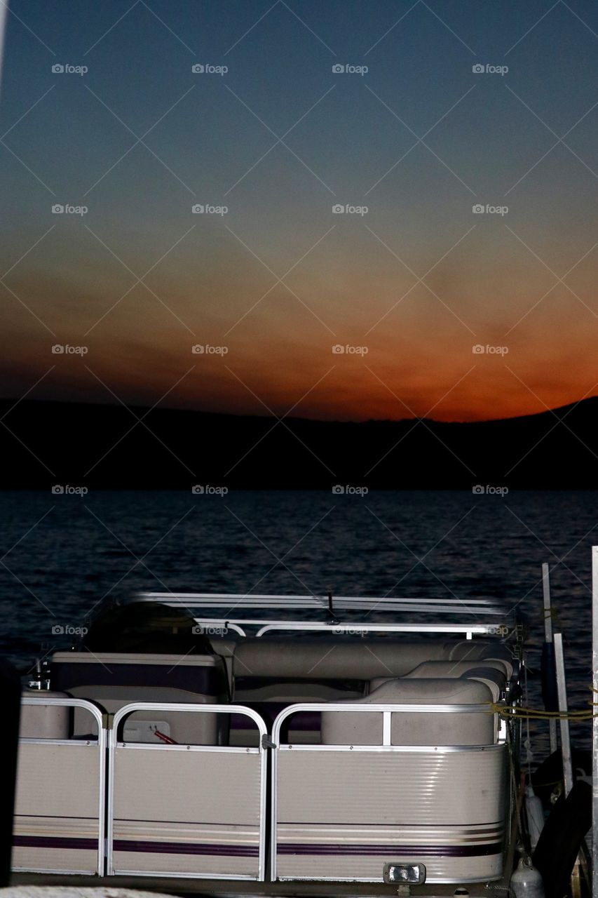 Lake boat tied to dock at sunset in the Adirondack mountains 