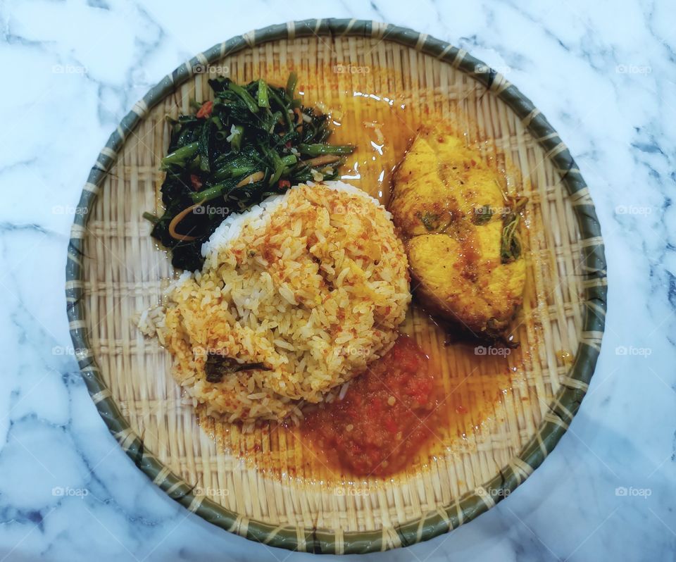 An Asian  Malay  Nasi Padang. (White rice with Asam  Fish  and Gravy  and Fried Vegetable with shrimp paste.