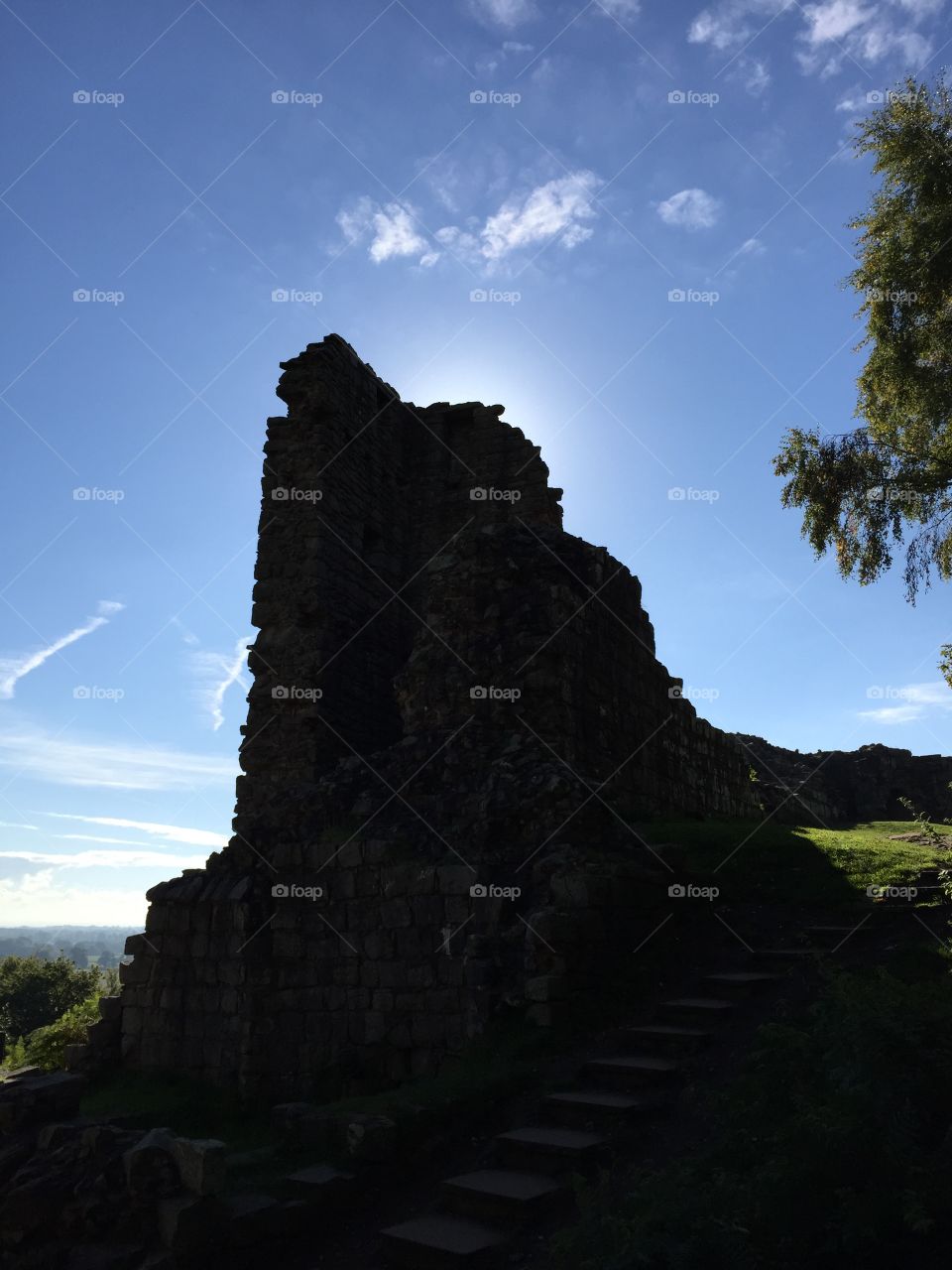 The lower curtain wall at Beeston Castle in silhouette against the autumn sun