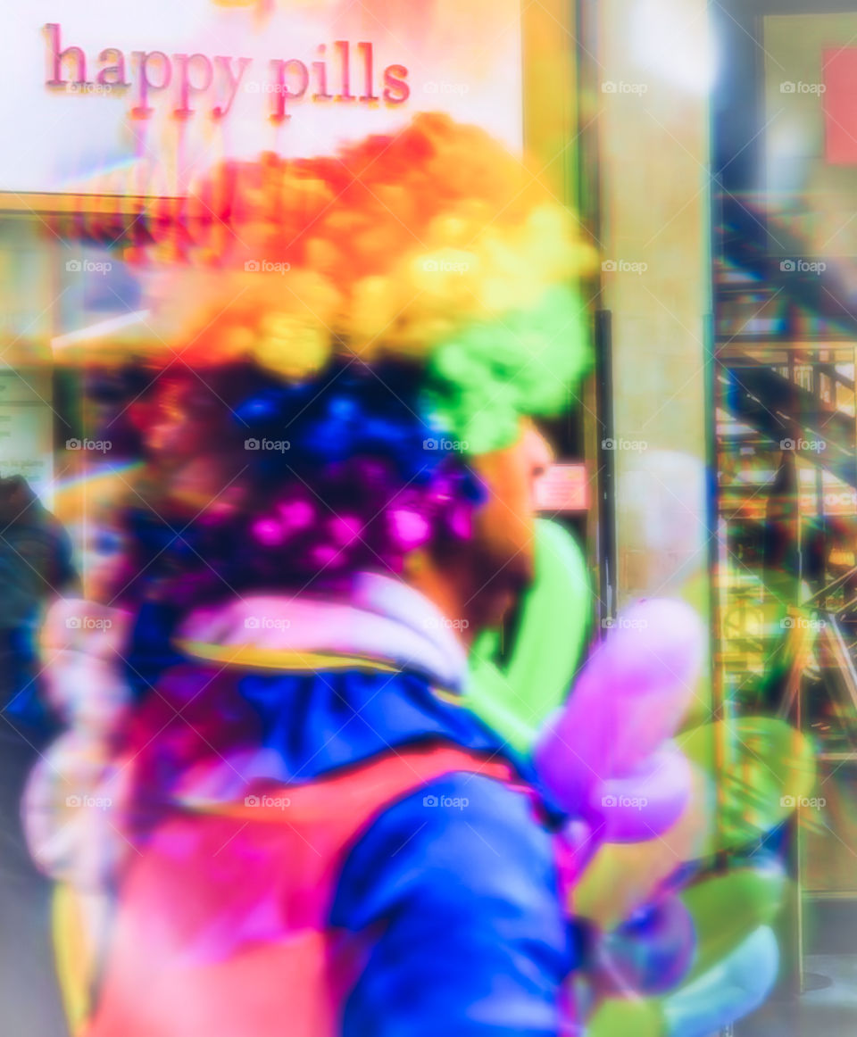 A brightly coloured clown, briskly past a sign reading Happy Pills. The image is heavily distorted