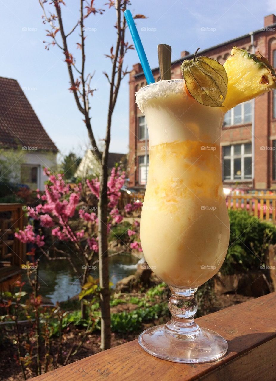 Yellow cocktail and beautiful sunny garden