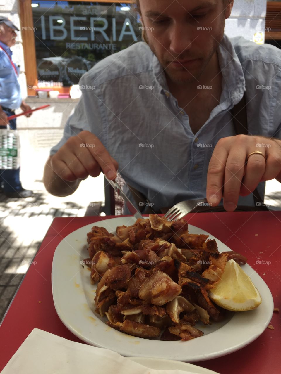 Person eating meat on a restaurant outdoors