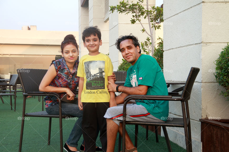 Smiling Indian family sitting outdoors