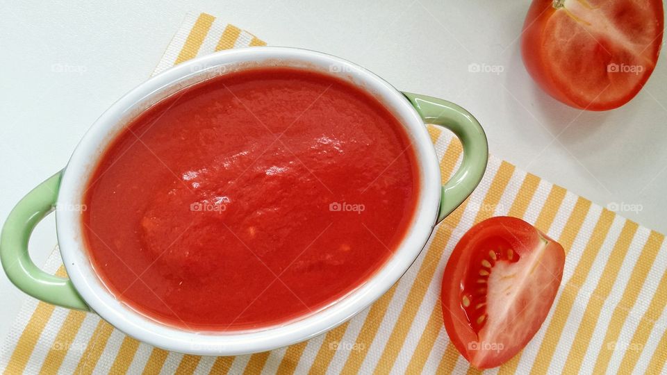 Bowl of tomato sauce and fresh tomato slice