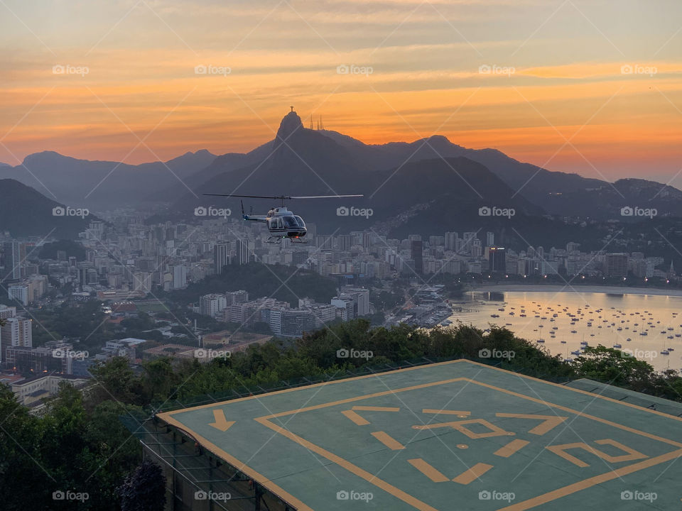 Rio de Janeiro at sunset light. Helicopter landing in his platform 